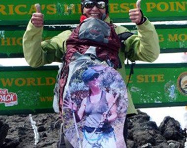 Trekker holding a photo at Uhuru Peak