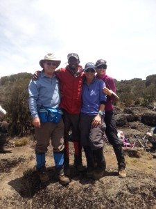 Leah H. and companions pose with a guide on Kilimanjaro