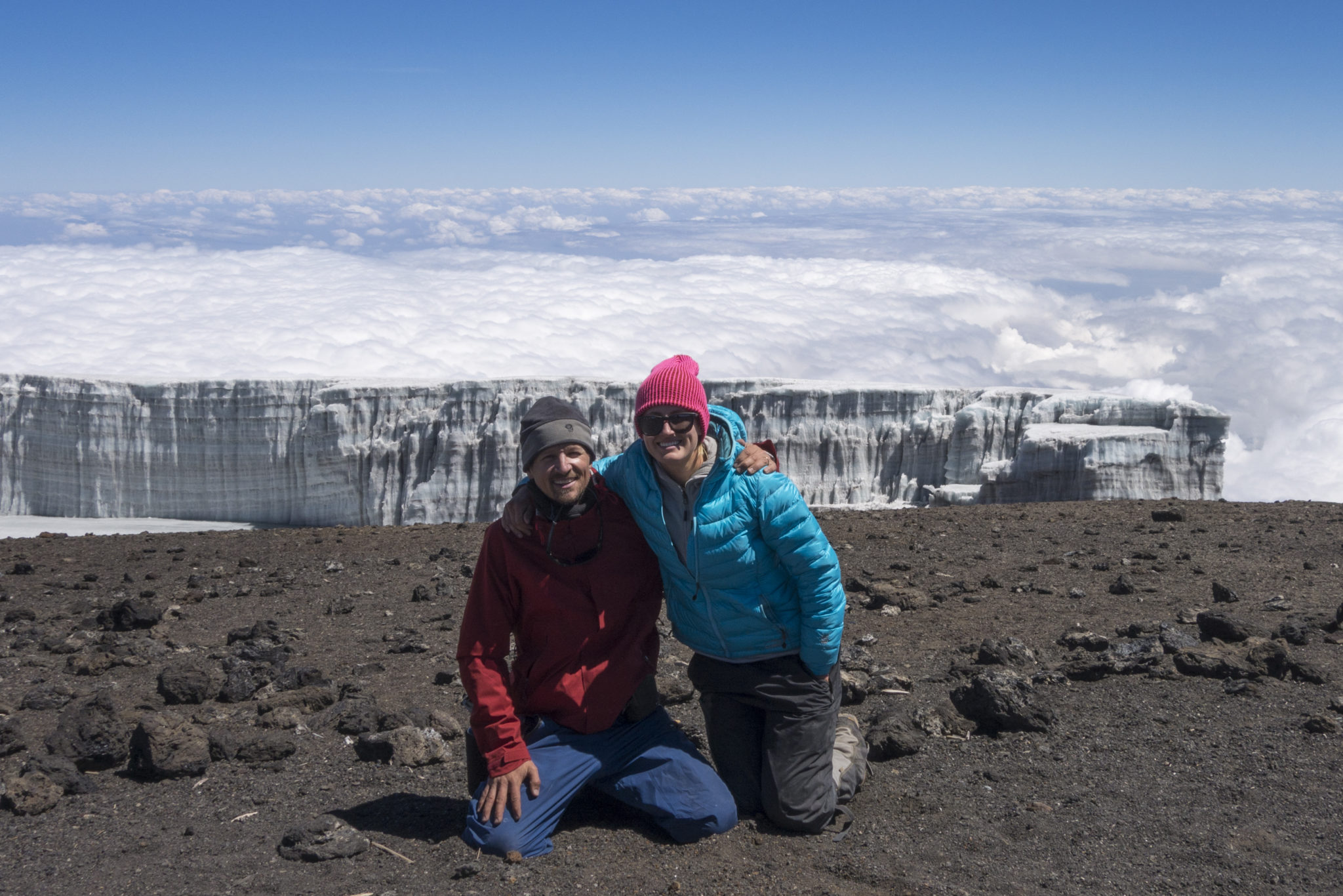 Jeff M. and companion pose against a backdrop of clouds and glaciers