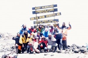 Natalie H. poses with her trekking group at the summit sign