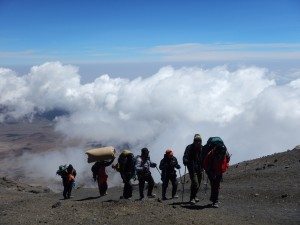 Porters high through clouds to carry goods to camp