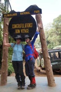 Natalie H. and her companion pose at the entrance of Kilimanjaro national park