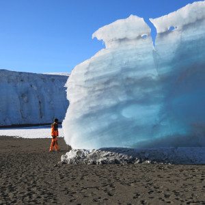 A porter stands near a large glacier