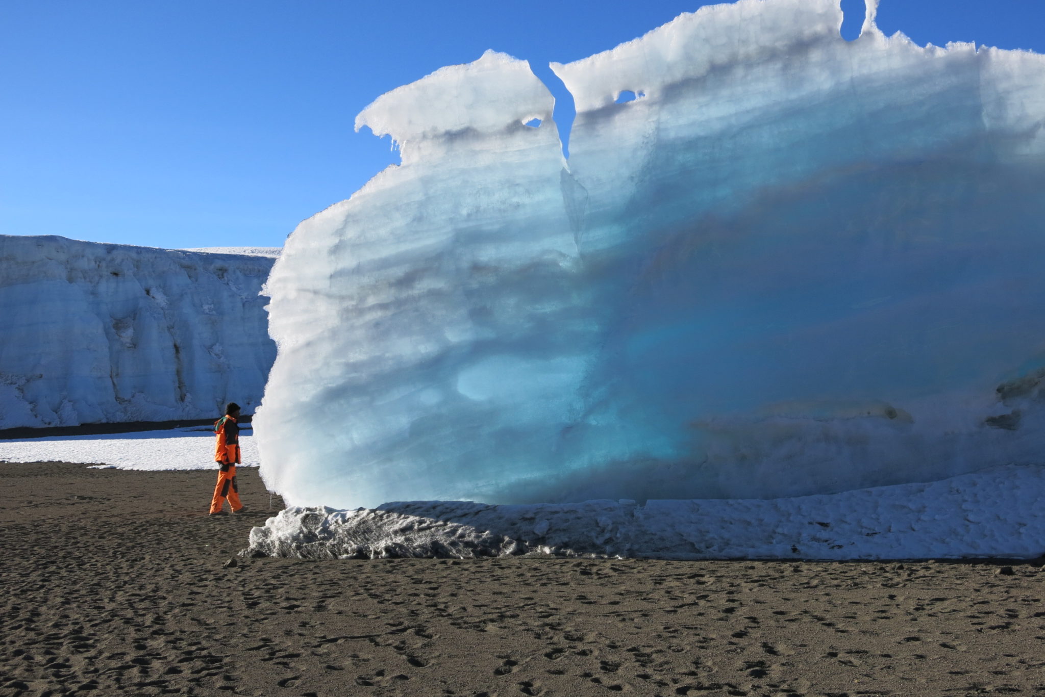 A porter stands near a large glacier