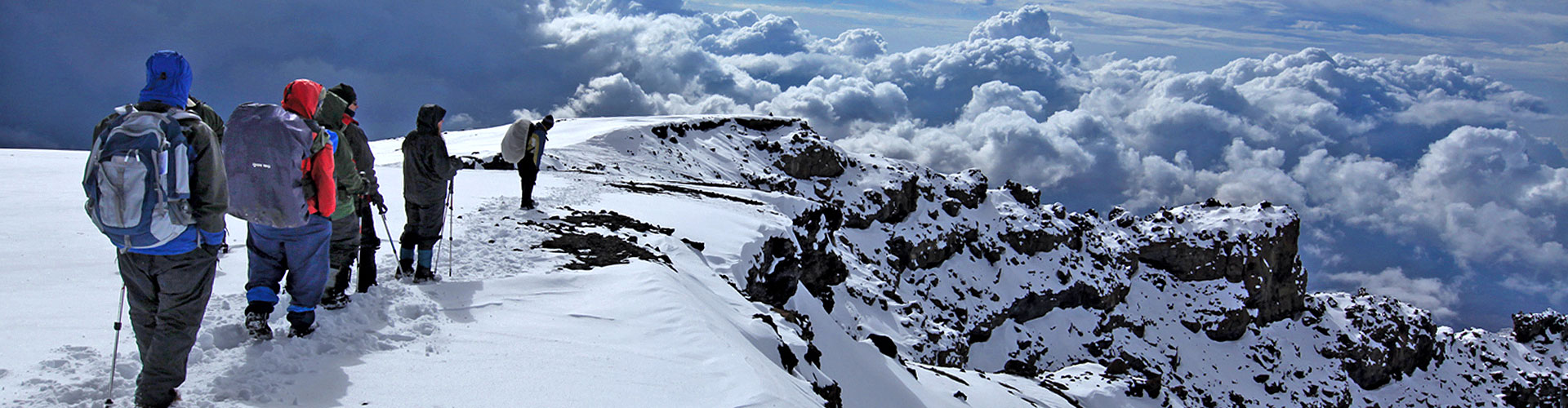 Trekkers take a snowy trail towards the clouds