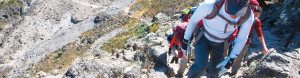 Team of trekkers ascend a rocky outcropping