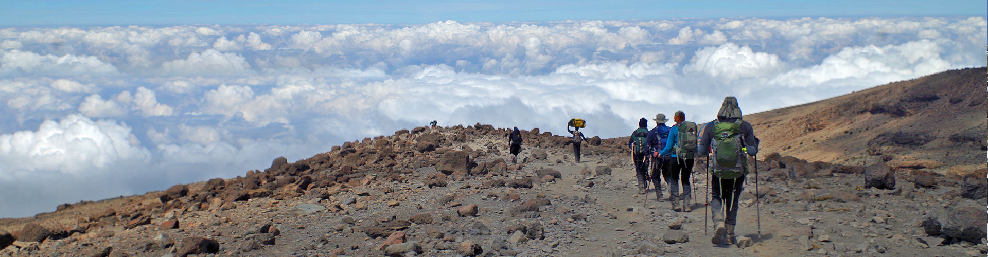 Trekkers descend towards the clouds