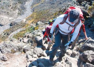 Trekkers climbing steep rocks
