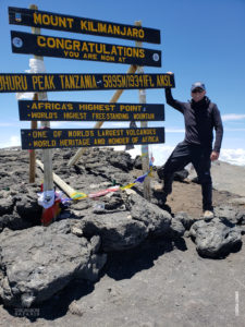 retired firefighter at summit of mount kilimanjaro