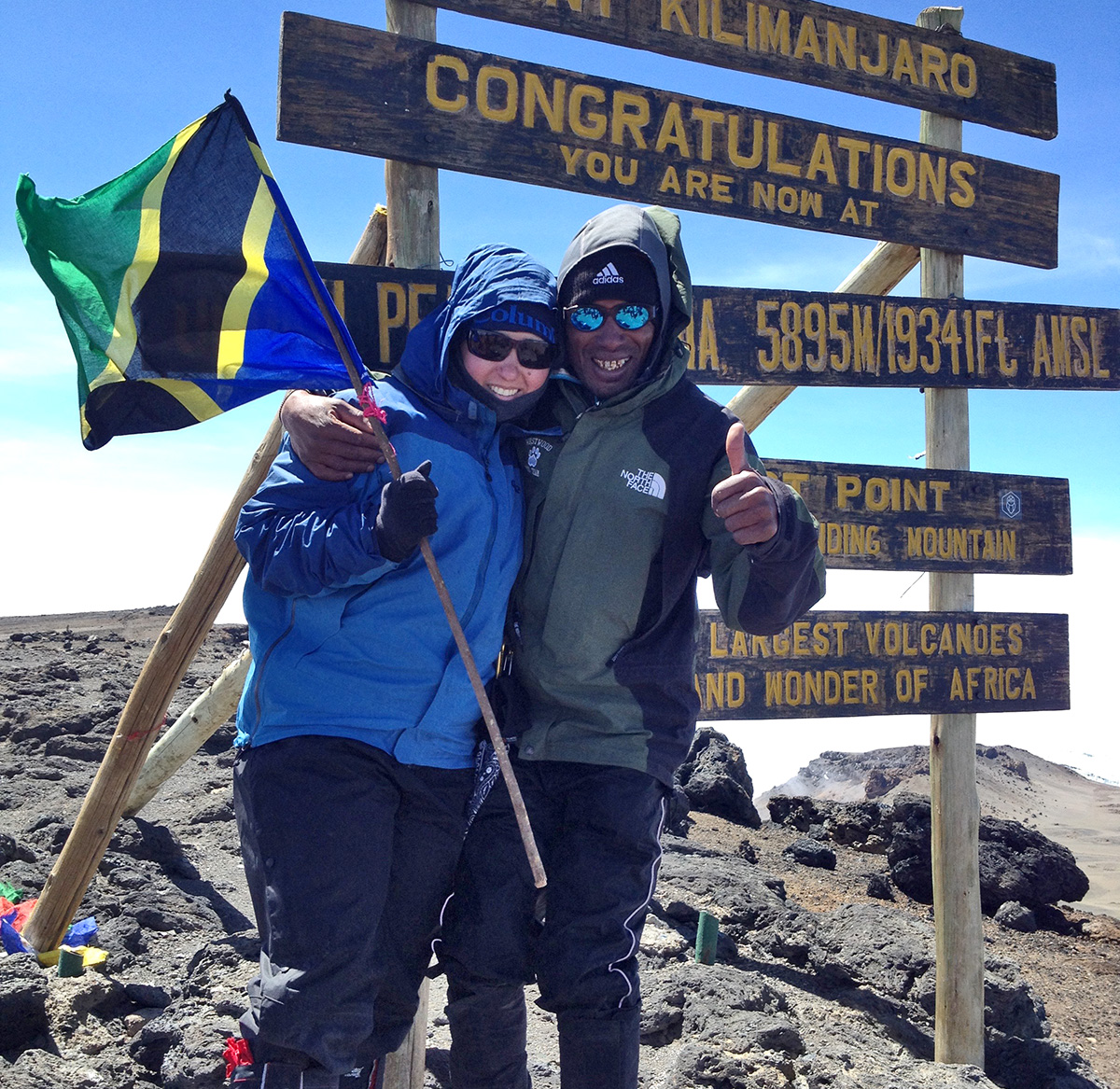 thomson trekker with personal porter at summit of mount kilimanjaro