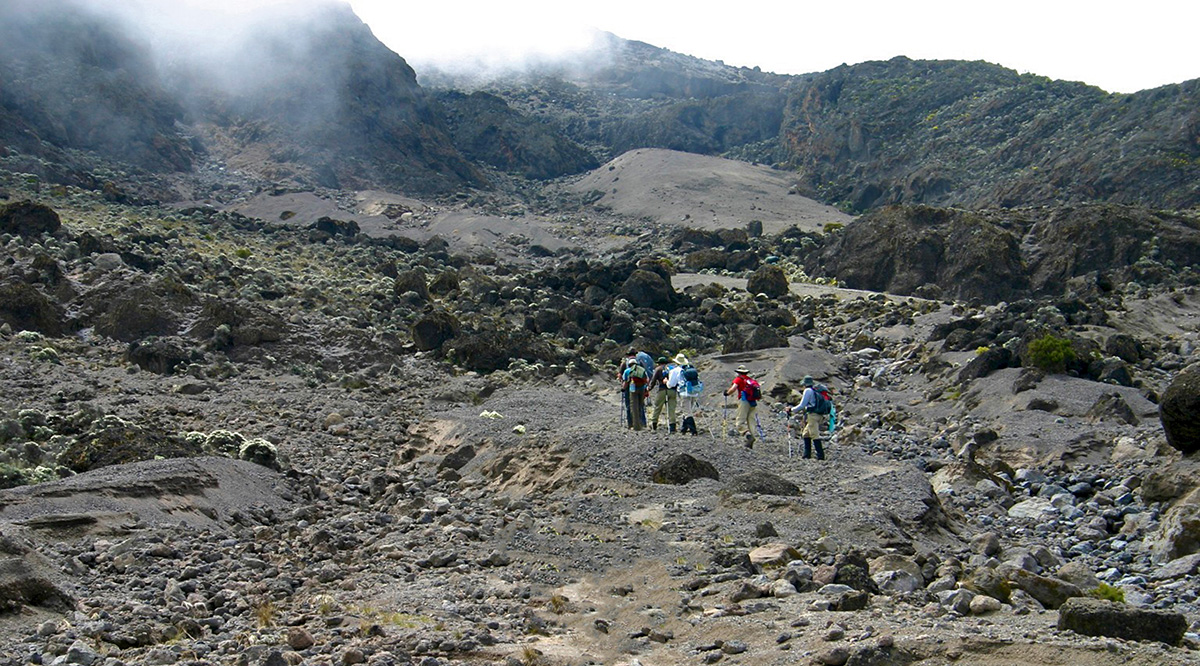 trekking through the volcanic rock landscape of kilimanjaro