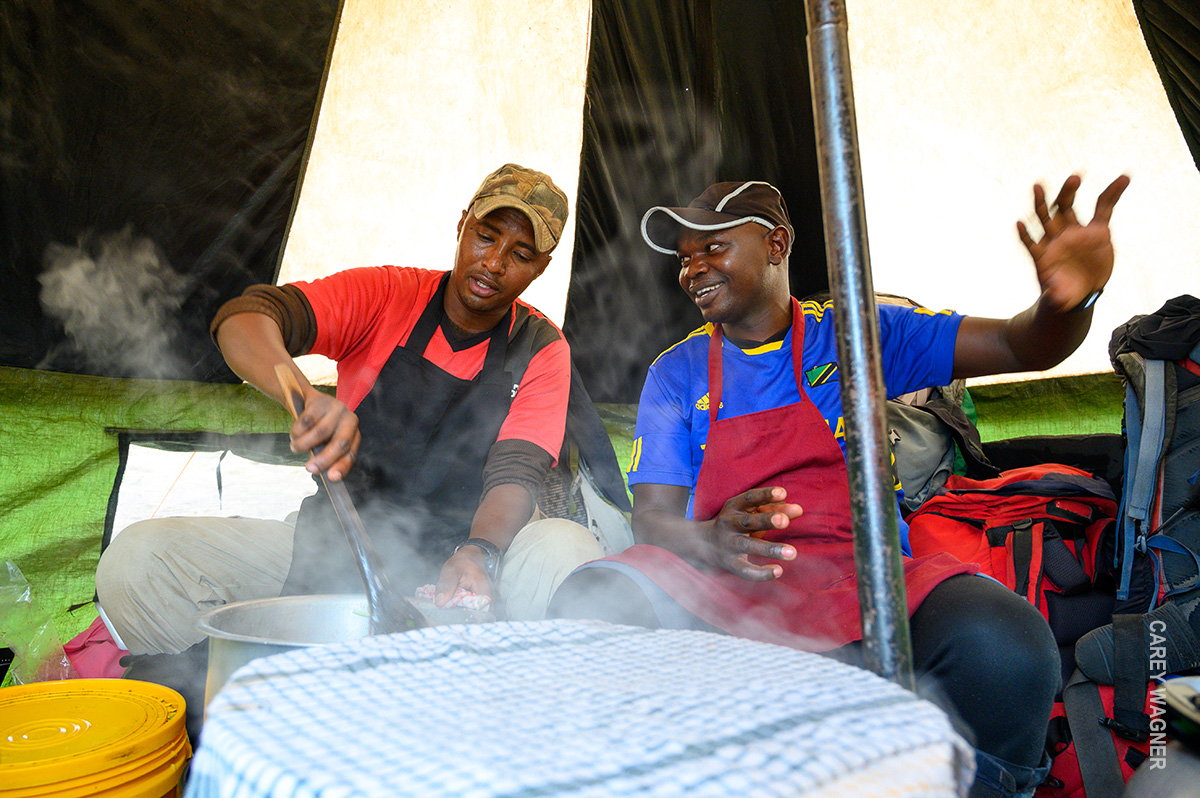 cooks preparing meal in kitchen tent
