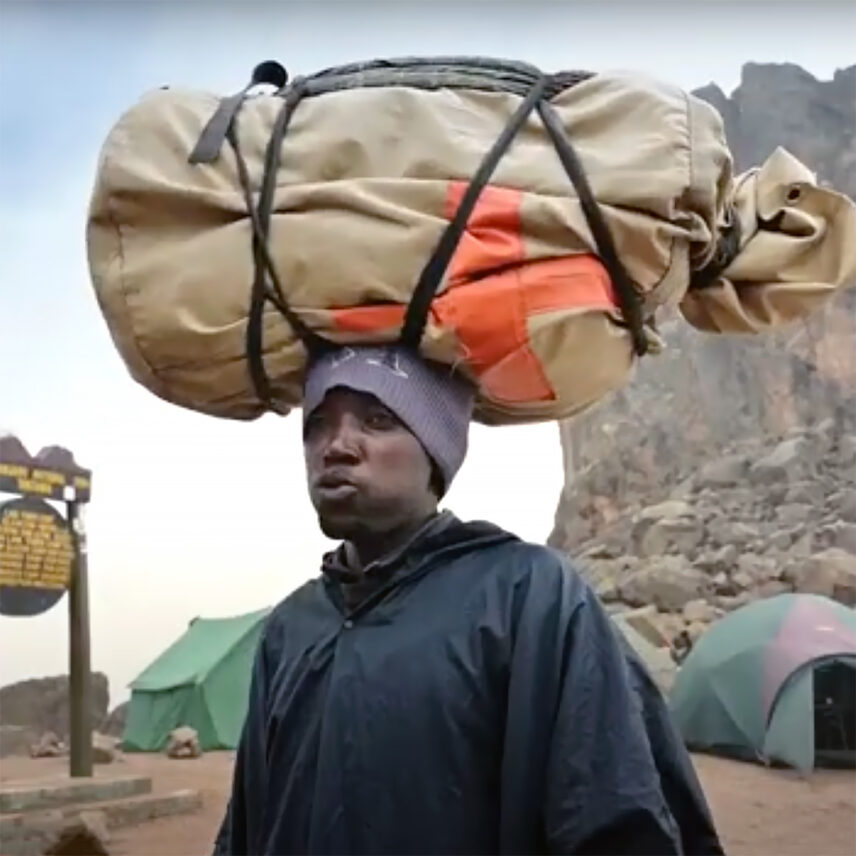 porter on kilimanjaro with bag on head
