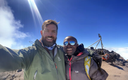 kilimanjaro guide gabriel with thomson staffer lewis at uhuru peak summit