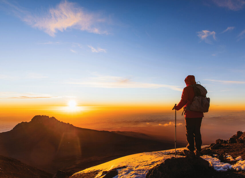 trekker near summit of mount kilimanjaro at sunrise