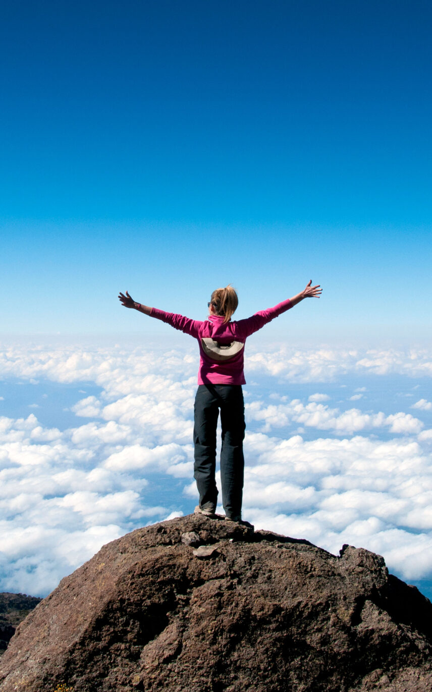 woman standing above clouds on kilimanjaro